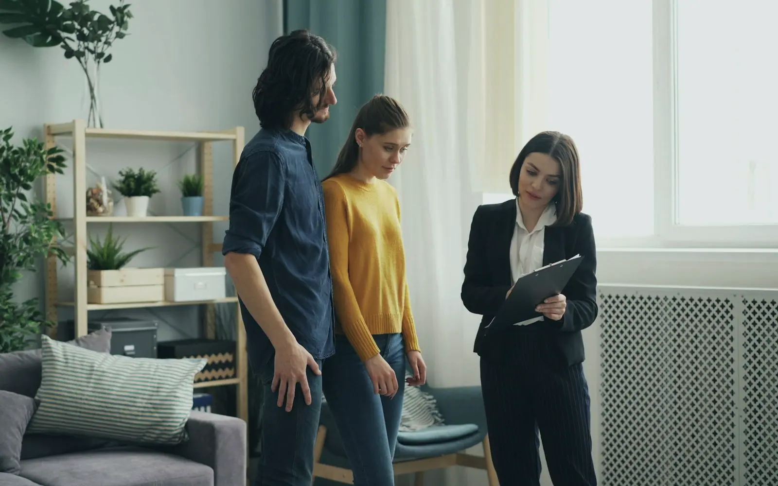 An estate agent showing a couple around a flat
