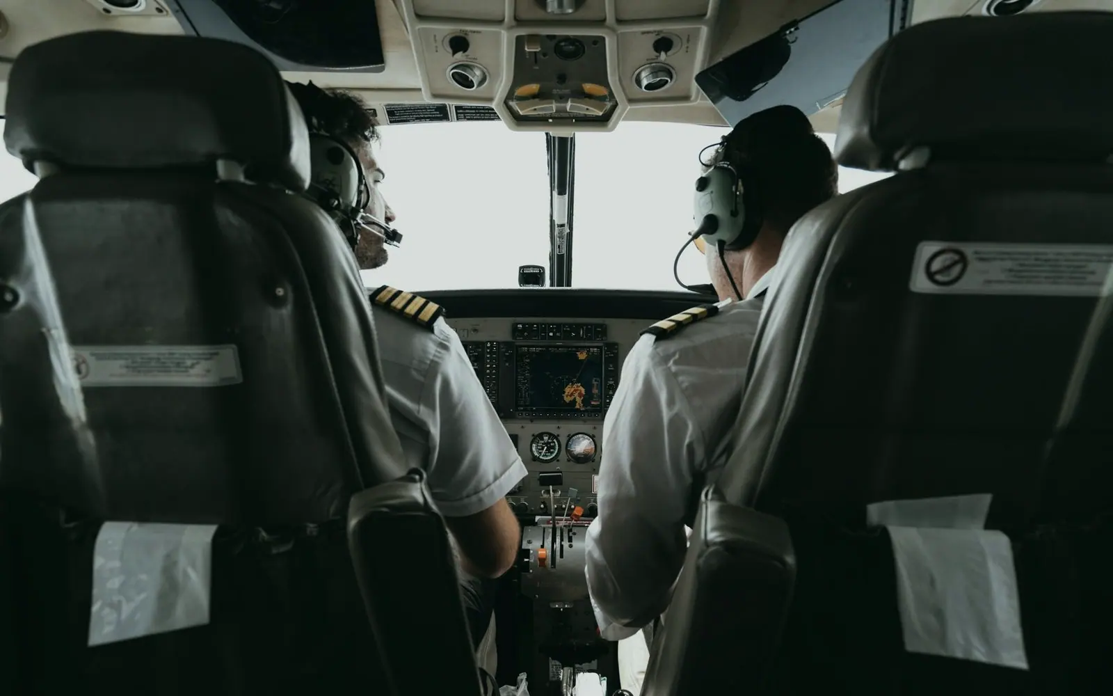 Two pilots at the controls in an aircraft cockpit